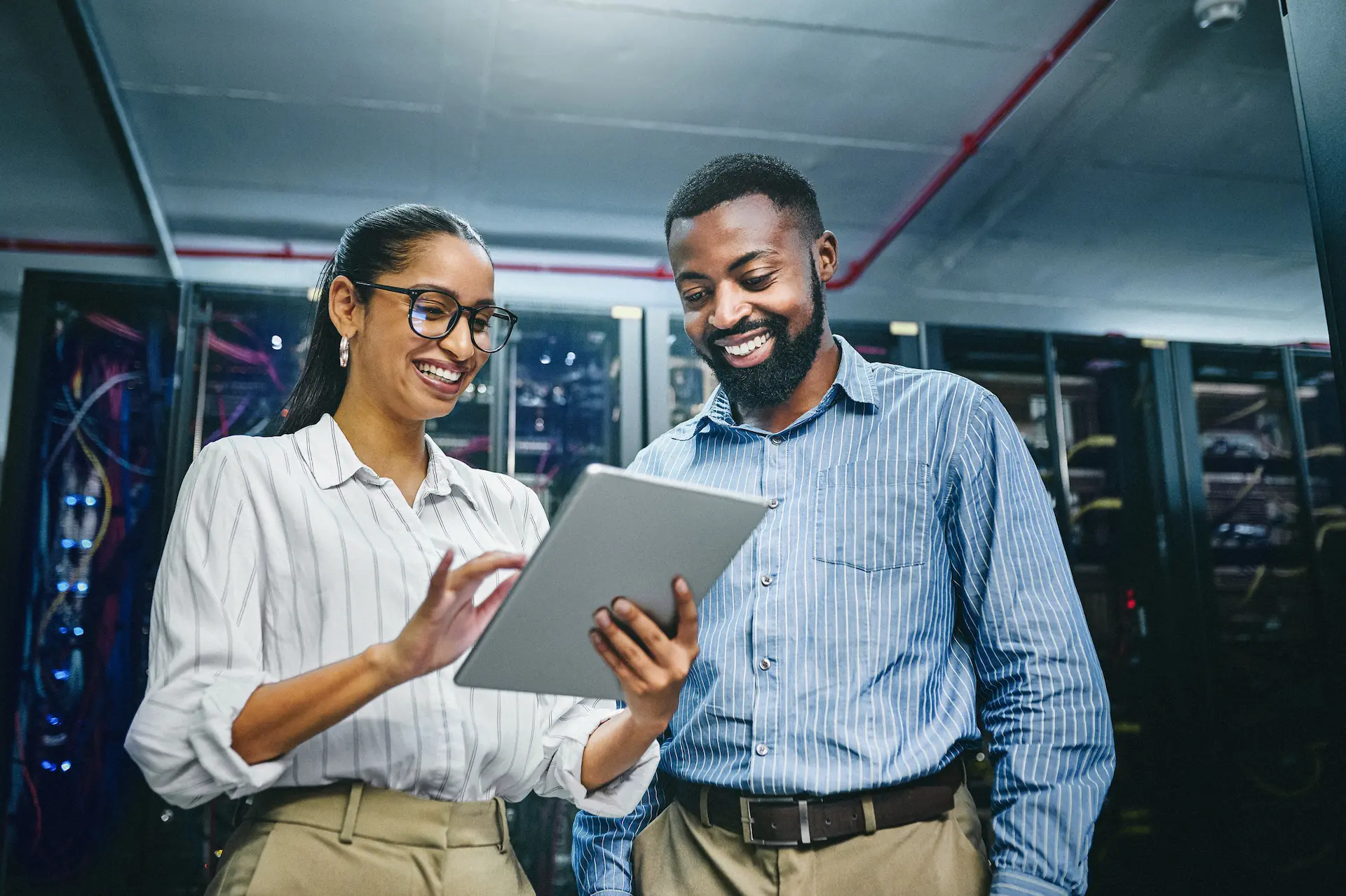 Shot of two young technicians using a digital tablet while working in a server room